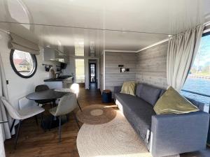 a living room with a couch and a table at Svencele Boats laivai-namai kuriems nereikia laivavedžio teisių in Svencelė