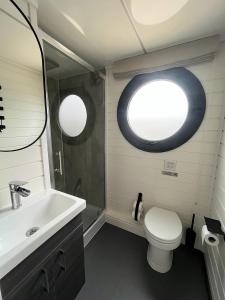 a bathroom with a sink and a toilet and a window at Svencele Boats laivai-namai kuriems nereikia laivavedžio teisių in Svencelė +34 photos