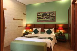 a bedroom with a large bed with two lamps and a bed sidx sidx sidx sidx at The Green Zhurga Suite in Kerobokan
