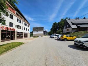 an empty street in a small town with cars parked at Sreća Plitvice in Plitvička Jezera
