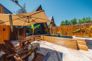 patio con sedie, ombrellone e piscina di Tree Bungalov Maşukiye a Kartepe