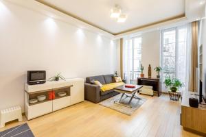 salon z kanapą i telewizorem w obiekcie GuestReady - Modern apartment in a prime location w Paryżu