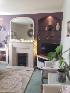 a living room with a fireplace and a mirror at Lavender Cottage, a pretty period cottage in Louth in Louth