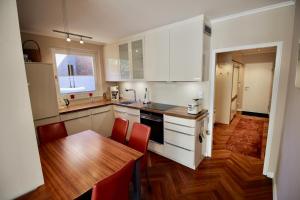 a kitchen with white cabinets and a wooden table at Seepferdchen Suite in Timmendorfer Strand