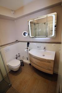 a bathroom with a sink and a toilet and a mirror at Seepferdchen Suite in Timmendorfer Strand +12 photos