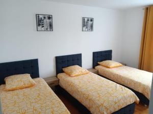 a room with three twin beds with yellow sheets at Gîte Coccinelle in Saint-Aignan