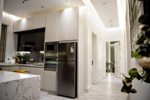 a kitchen with a stainless steel refrigerator and appliances at Luxury Smart Apartment E12 in Riyadh