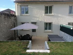 a white umbrella in the yard of a house at Gîte Coccinelle in Saint-Aignan