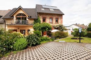 a house with a brick driveway in front of it at Ferienwohnung Lilly in Eitelborn