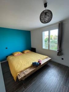 a bedroom with a bed with a blue wall and a window at Maison de village avec terrasse in Valensole