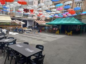 a patio with tables and chairs with umbrellas at Joy's house in Catania