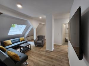 ドルトムントにあるCity Apartのリビングルーム(青いソファ、椅子付)