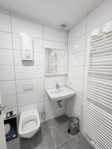 ドルトムントにあるCity Apartのトイレと洗面台を備えた白いバスルーム