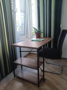 een houten tafel en een stoel met een plant erop bij Дом Крумови in Boergas