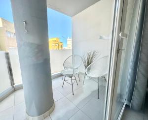 balkon z 2 krzesłami, stołem i słupem w obiekcie Pineapple Sorbet piscina, doble terraza, cocina completa y WIFI w Corralejo