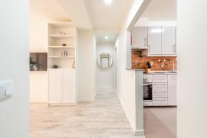 a white kitchen with white cabinets and a hallway at GuestReady - Great 3BDR apartment in Oeiras! in Oeiras