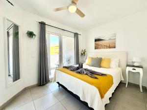 sypialnia z łóżkiem i dużym oknem w obiekcie Pineapple Sorbet piscina, doble terraza, cocina completa y WIFI w Corralejo