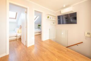 a living room with white walls and a wooden floor at GuestReady - Sunny spacious in Belém in Lisbon