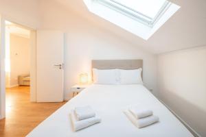 a bedroom with a white bed with two pillows at GuestReady - Sunny spacious in Belém in Lisbon
