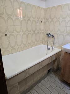 a bath tub in a bathroom with a sink at Sara Family Home in Struga