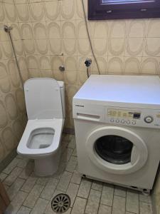 a small bathroom with a washing machine and a toilet at Sara Family Home in Struga