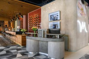 a bar in a restaurant with a counter and chairs at Mercure Debrecen in Debrecen