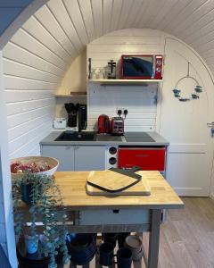 a small kitchen with a table in a room at Dreckly cabin - Lydcott Glamping with Cornish sea views in Looe