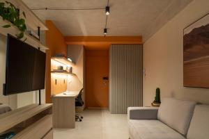 a living room with a couch and a television at Loft Marília City in Marília
