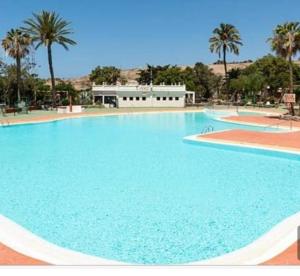 una gran piscina azul con palmeras en el fondo en La Casablanca, en Pasito Blanco 13 fotos más