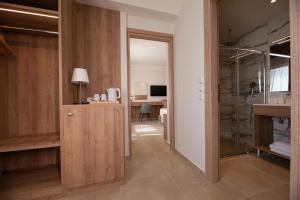 ein Bad mit einer ebenerdigen Dusche und einem Waschbecken in der Unterkunft ALPHA APARTMENTS Free Shuttle from and to the Airport in Spáta
