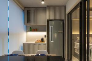 a kitchen with a refrigerator and a table and chairs at Loft Marília City in Marília