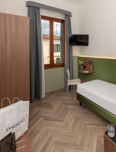 a small room with a bed and a window at Hotel Casa Del Pellegrino in Padova