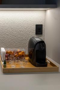 a toaster sitting on a wooden tray with glasses at Loft Marília City in Marília