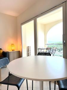 un tavolo bianco con sedie in una stanza con finestre di Veneto Luxury Apartment a Olbia