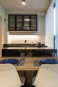 a kitchen with a wooden table with blue plates on it at Loft Marília City in Marília