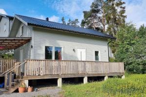a small house with a wooden deck in front of it at Strandnära skärgårdshus in Gustavsberg