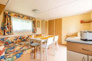 a kitchen and dining room with a table and chairs at L'héberge du lac d'Isachris mh4 in Queyrac