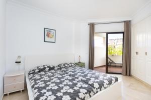 a bedroom with a bed with a black and white comforter at Apartamento con vistas al jardín in Puerto de la Cruz +15 photos