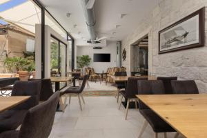 a restaurant with wooden tables and chairs and a tv at NEW - Casa Columba - 4 Star Design Boutique Hotel with Outdoor Pool & Private Garden in Makarska