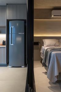 a refrigerator in a room next to a bed at Loft Marília City in Marília