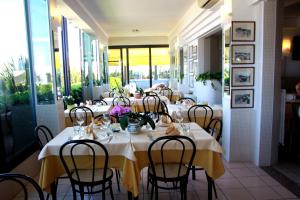 a restaurant with tables and chairs with flowers on them at Hotel Angela in Fano
