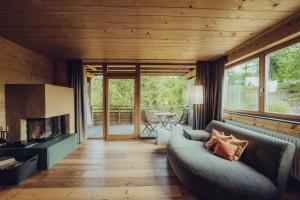 a living room with a couch and a fireplace at Holzhotel Forsthofalm in Leogang