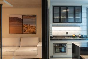 a living room with a couch in a kitchen at Loft Marília City in Marília