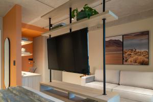a living room with a flat screen tv on a wall at Loft Marília City in Marília