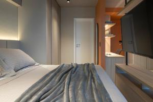 a bedroom with a bed and a television in it at Loft Marília City in Marília