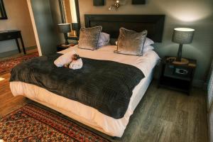 a bedroom with a large bed with two stuffed animals on it at House Vos in Hermanus