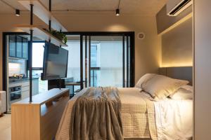 a bedroom with a bed and a flat screen tv at Loft Marília City in Marília