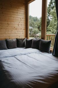 un letto grande in una stanza con una finestra di Thoma's hut-თომას ქოხი a Batumi
