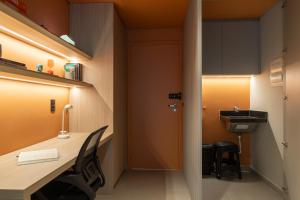an office with a desk and a sink in a room at Loft Marília City in Marília