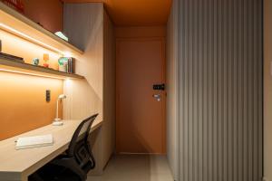 an office with a desk with a chair and a door at Loft Marília City in Marília